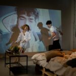 Un jeune couple s'amuse et joue en projetant un film dans le cadre douillet de leur chambre.